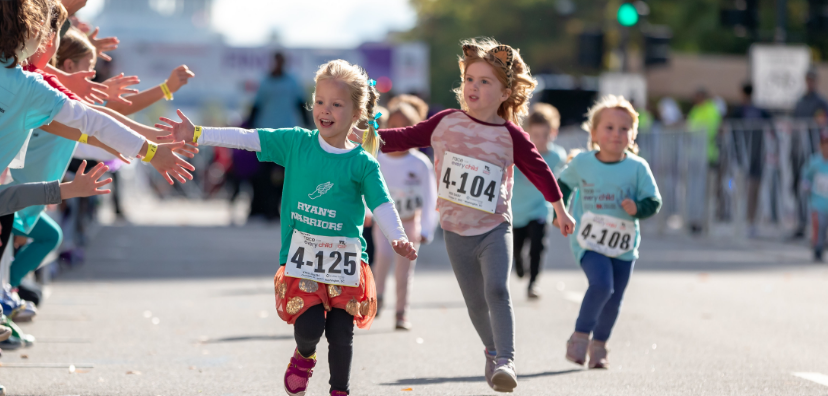 Child high fiving other children while running during last year's Race