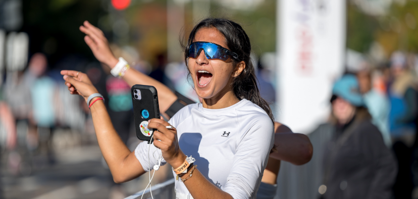 Girl smiling enthusiastically at her phone during last year's Race
