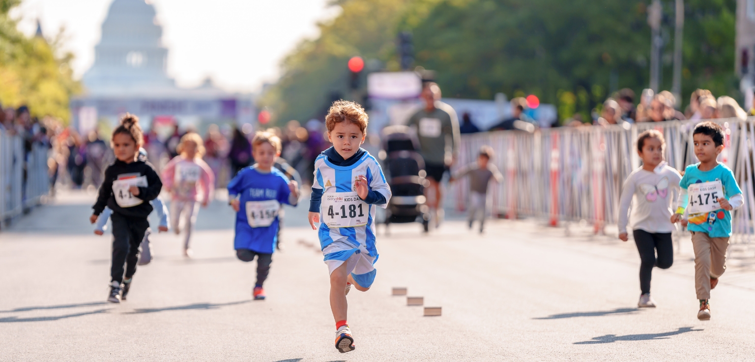 Child high fiving other children while running during last year's Race