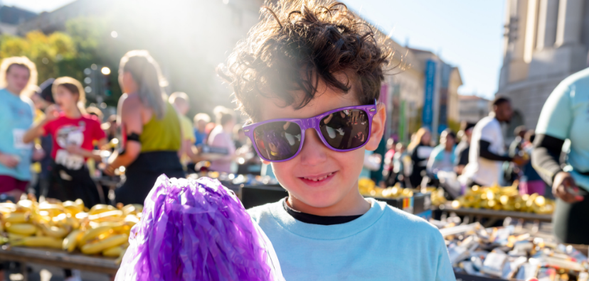 Boy wearing purple glasses smiling at the camera