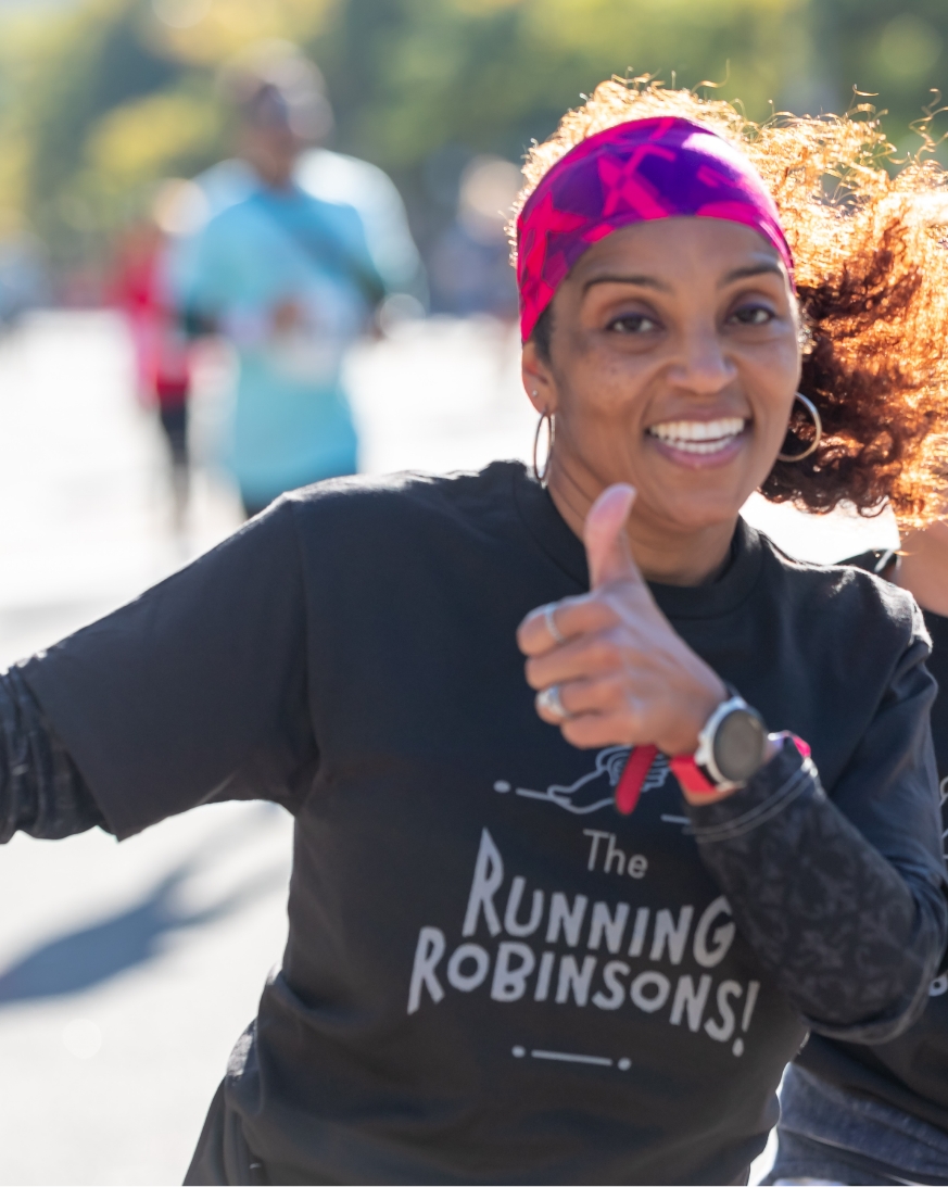 Woman smiling and giving a thumbs up to the camera