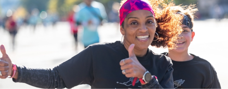 Woman smiling and giving a thumbs up to the camera